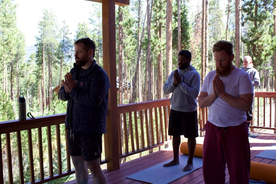 Three men in a morning practice on the deck