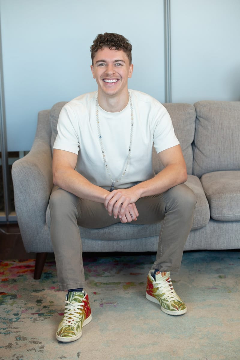 Savon, founder of Chiron Coaching, seated and smiling